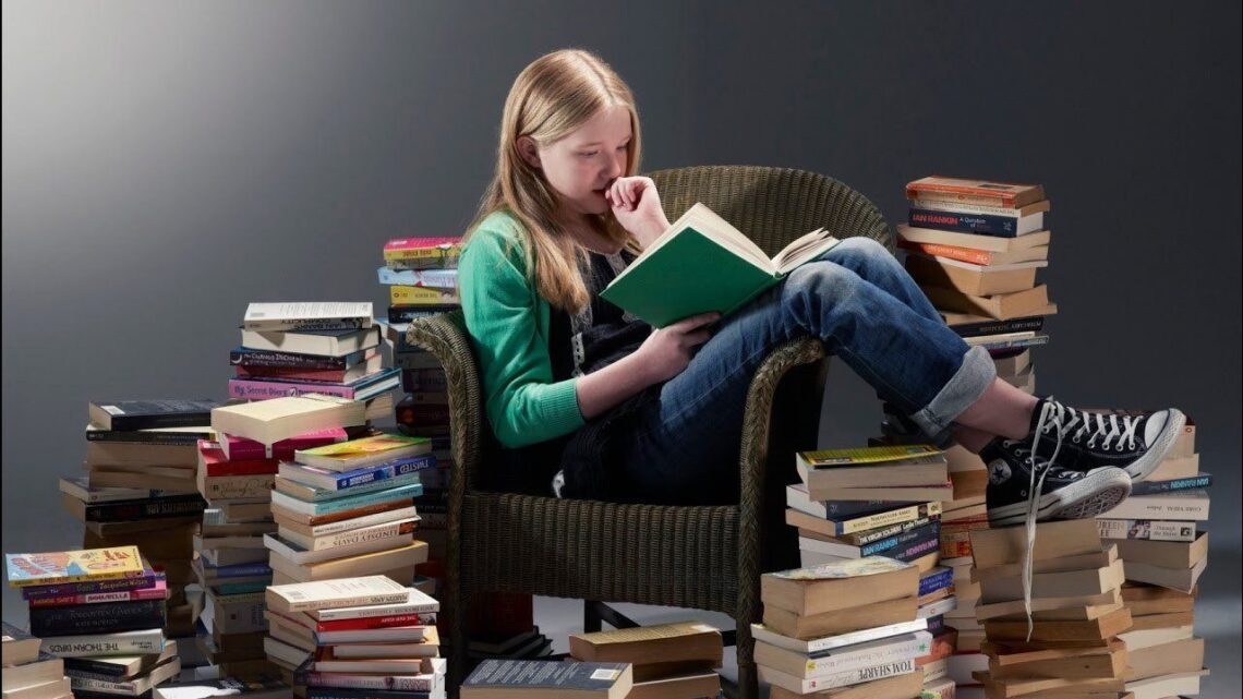 Menina lendo rodeada de livros - Como descobrir seu gênero literário/ Reprodução i.pinimg